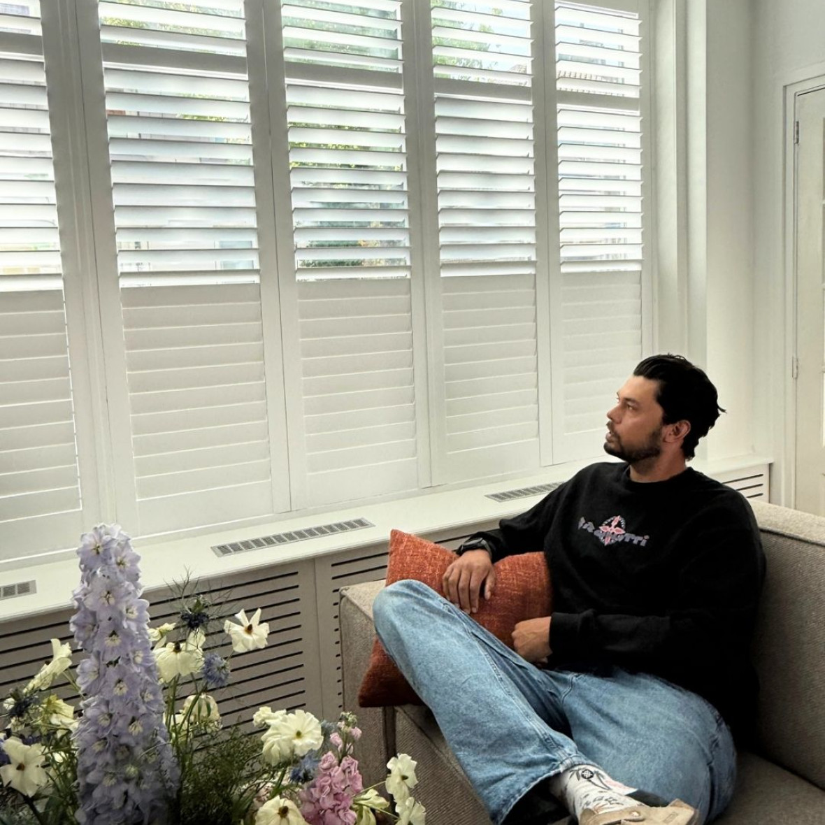 Kiran kijkt naar shutters woonkamer