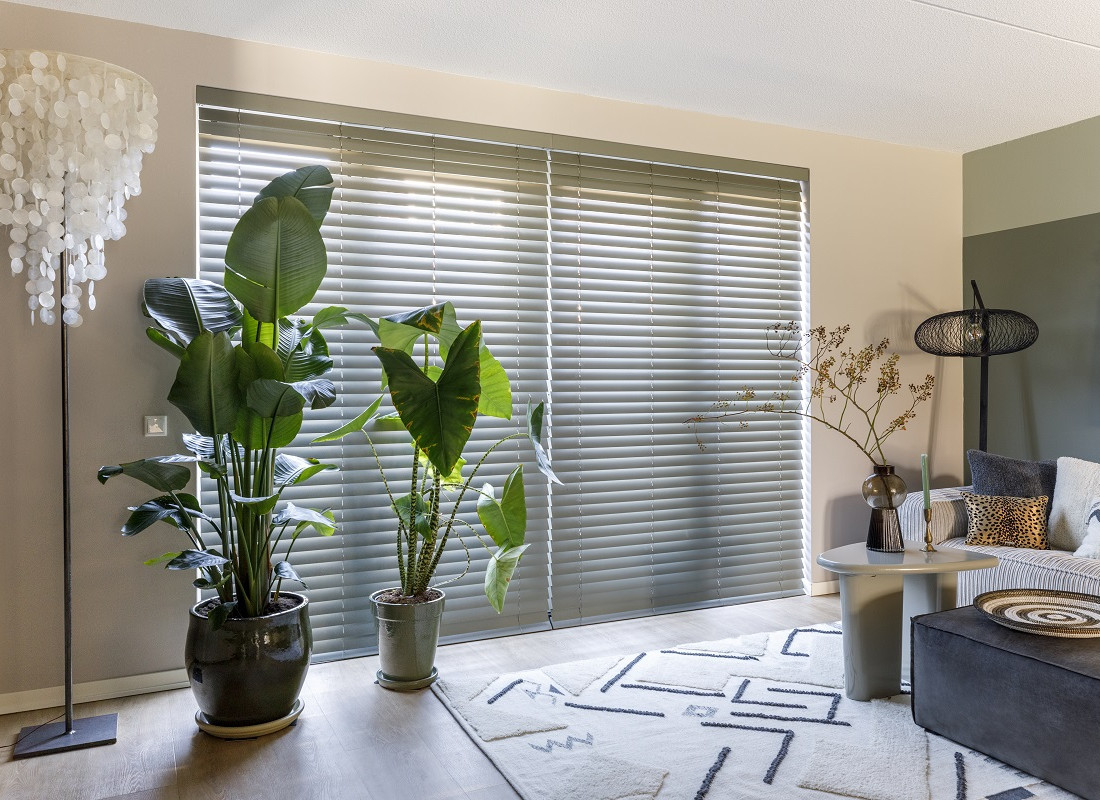 Sfeerfoto van woonkamer met houten jaloezieën in kleur 7003 Moss Grey